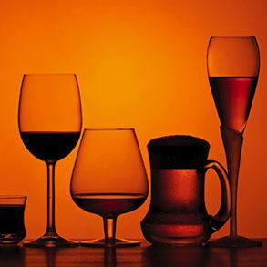 Several glasses of varying sizes with differing quantities and types of alcohol
